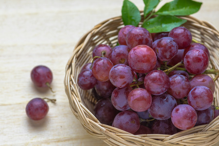 purple round grapes on old wooden tableの写真素材