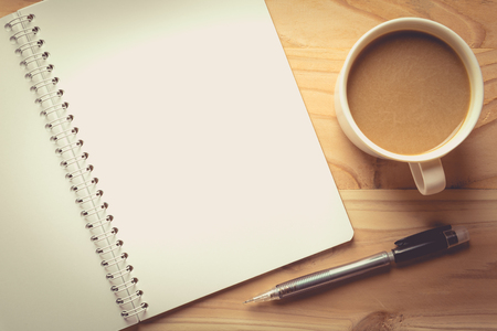 notebook checked with a  pencil   and a cup of coffee , vintage toneの写真素材