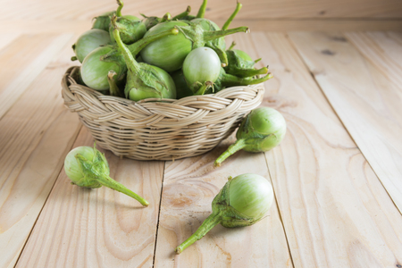 eggplants in a basket on the wooden floor.の写真素材