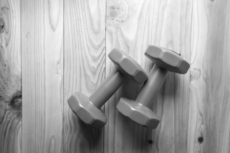 Pair of red 1 kg dumbbells on wood  , black and white.の写真素材