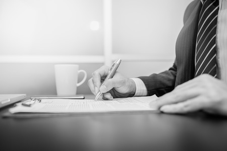 Business man signing a contract  . Close-up photo , black and white.の写真素材