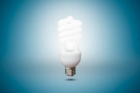 Compact Fluorescent bulb in blue backgroundの写真素材