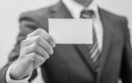 Man's hand showing business card - closeup sho , black and white.の写真素材