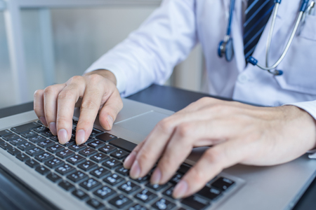 Close-up of a medical worker typing on laptopの写真素材