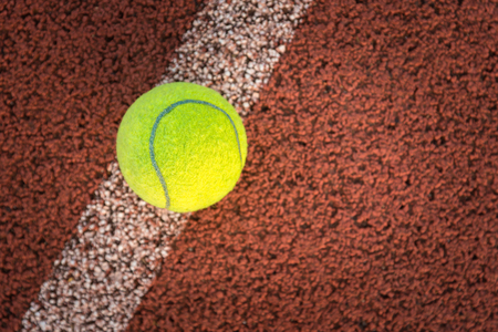Close up of tennis ball on clay court.の写真素材