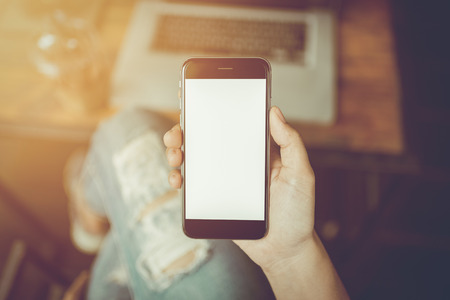 Hand holding smartphone white screen, vintage toneの写真素材