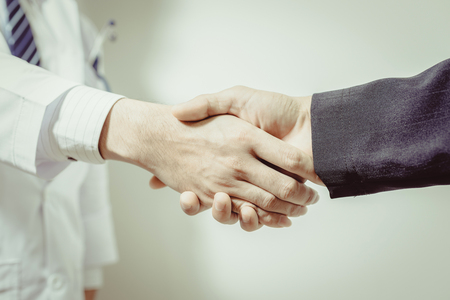 doctor and her lawyer shaking hands , vintage toneの写真素材
