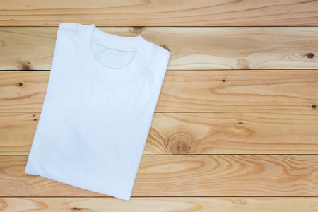 White T-Shirt on wood teble background , Top viewの写真素材