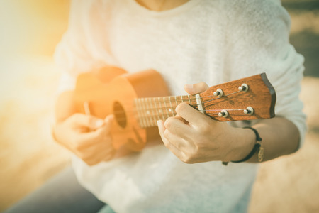 Young woman playing on Ukulele , sunset  vintage toneの写真素材
