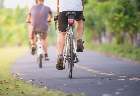 Cyclists ride along bike path in parkの写真素材