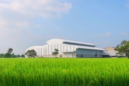 Factory in the middle of a green farmland on a cloudy dayの写真素材