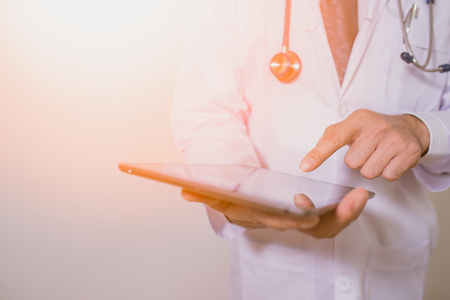 Doctor using a digital tablet on white backgroundの写真素材