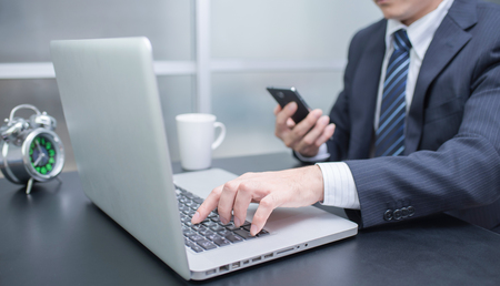 Businessman using laptop and mobile phoneの写真素材