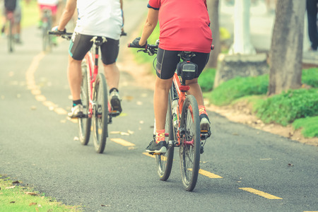 Cyclists ride along bike path in park , vintageの写真素材