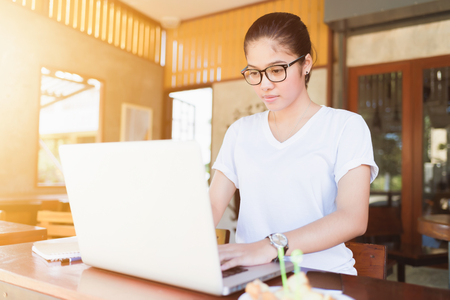 Business entrepreneur asian girl working online on laptop in cafe. business entrepreneur asian using laptop in home.の写真素材