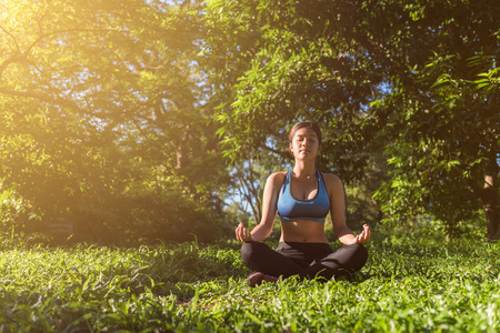Yoga in the park, outdoor with effect light, health woman, Yoga woman. Concept of healthy lifestyle and relaxation.の写真素材