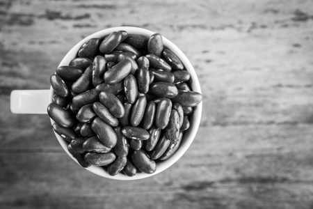 Red bean kidney in cup on wooden background, top viewの写真素材
