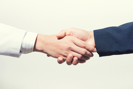 Man doctor and her lawyer shaking hands on white.の写真素材