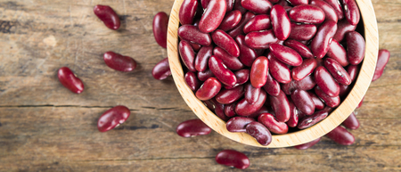 Red bean kidney in a bowl on wooden background, top view banner panoramic crop for copy space.の写真素材