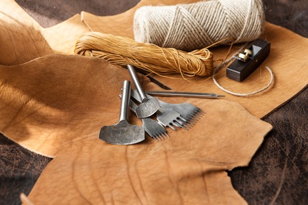 tools for homemade leathercraft on brown background