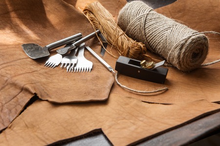 tools for homemade leathercraft on brown backgroundの写真素材