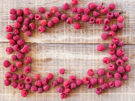 red rasberry in sunlight on wooden backgroundの写真素材