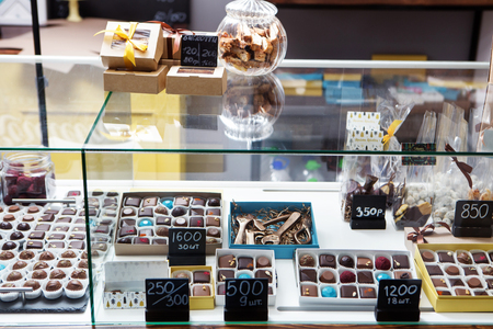 showcase with assorted chocolate candies in daylightの写真素材