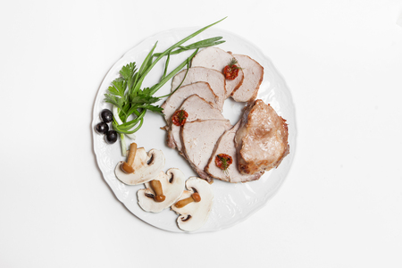 dish of pork with sauce and garnish isolated on whiteの写真素材