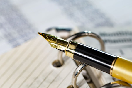 Close up of a fountain pen on a padlock on a business documentの写真素材