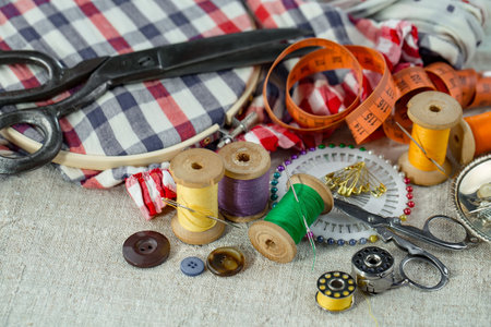 Sewing accessories on the table. Sewing tools, scissors, thread, needles, fabric.の写真素材