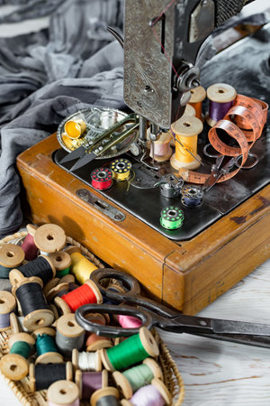 Sewing accessories on a wooden background. Sewing machine, scissors, thread, needles, pins.の写真素材