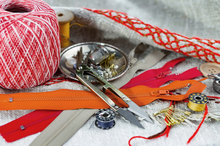 Sewing tools and accessories for needlework on fabric background.
