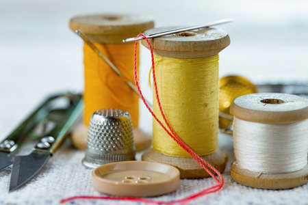 Spools of thread, thimble and scissors on a white backgroundの写真素材