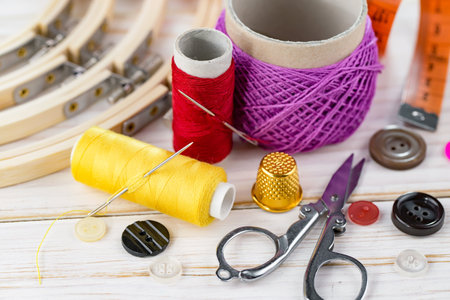 Sewing tools and accessories for needlework on a wooden background
