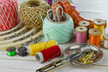 Sewing tools and accessories for needlework on a wooden background