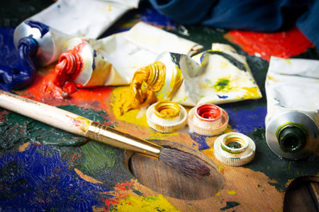 Paint brushes and palette with colorful paints on a dark background.の写真素材