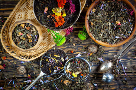 Dry tea in a bowl on a wooden table, top viewの写真素材
