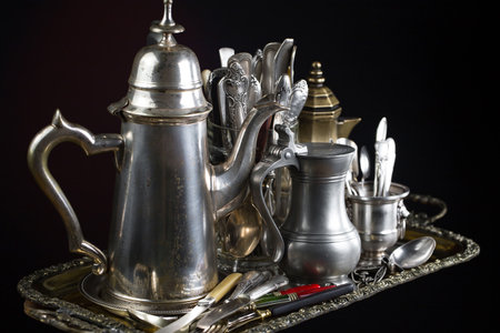 Antique silverware on a metal tray. Black background. Selective focus.の写真素材