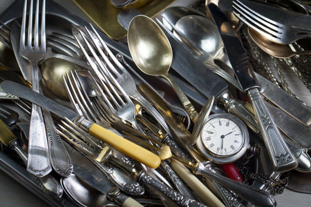 Old cutlery in a metal tray, close-up.の写真素材