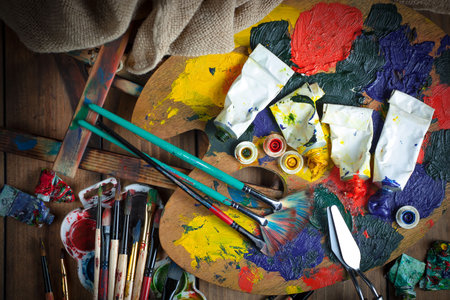 Paintbrushes and palette on a wooden table. Top viewの写真素材