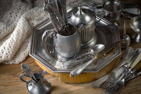 Vintage silverware and crockery on an old wooden table