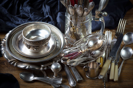 Vintage silverware and crockery on a wooden table.の写真素材