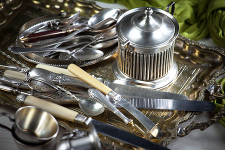 Vintage silverware and utensils on a metal tray.の写真素材