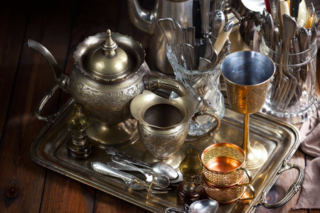 Antique silverware and coffee set on old wooden table background.の写真素材