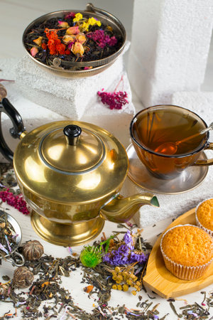 Tea set with dried flowers, cupcakes and teapot on white backgroundの写真素材