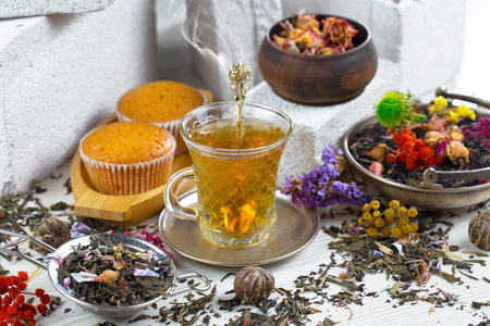 Tea hot drink on old background in composition with dried flowers and fruitsの写真素材