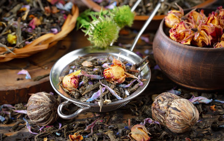Dry tea leaves with rose petals in a bowl on wooden backgroundの写真素材