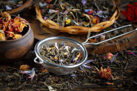 Dry tea with rose petals in a strainer on a wooden backgroundの写真素材