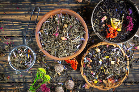 Dry tea leaves in bowls on a wooden table, top viewの写真素材