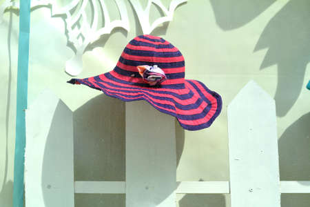 Female summer hat hanging on the wooden rustic fence.の写真素材